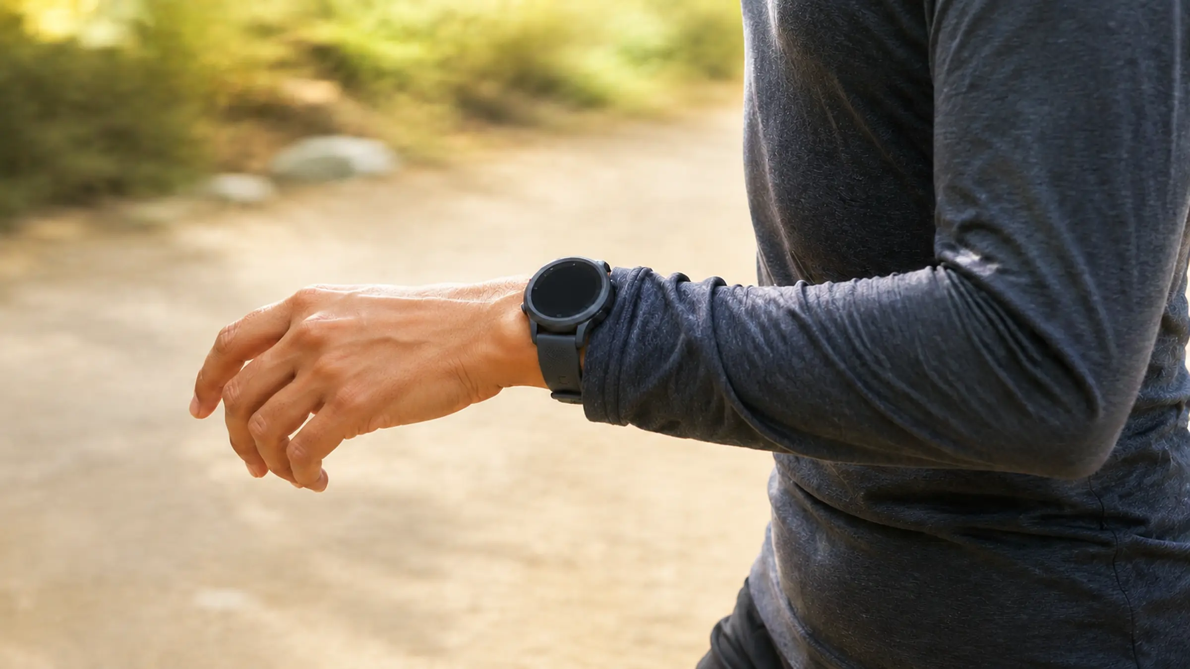 A runner checking a GPS watch on the wrist during a session
