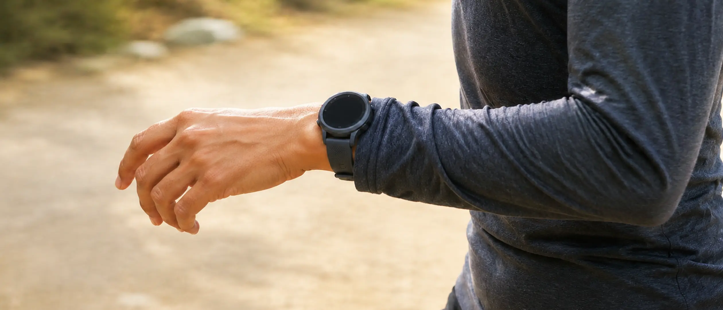 A runner checking a GPS watch on the wrist during a session