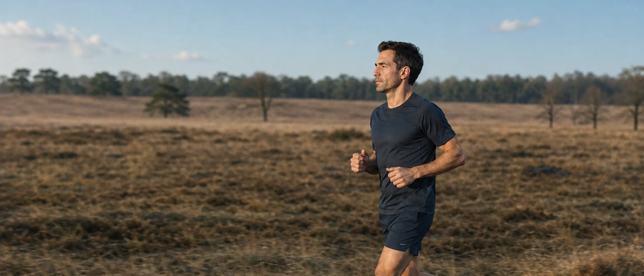 A runner crossing open heathland in late afternoon light